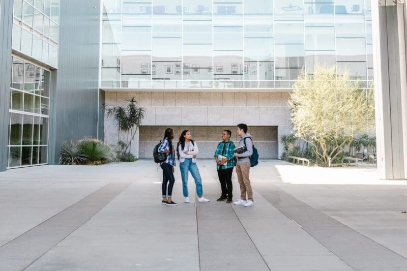 A group of young people standing in front of a concrete building