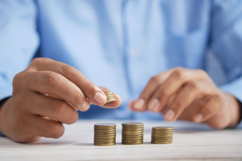 Person stacking three towers of coins